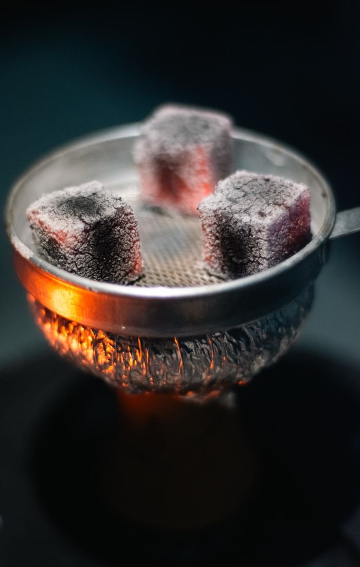 Services Close-up of glowing hookah coals on a traditional setup, showcasing vibrant heat.