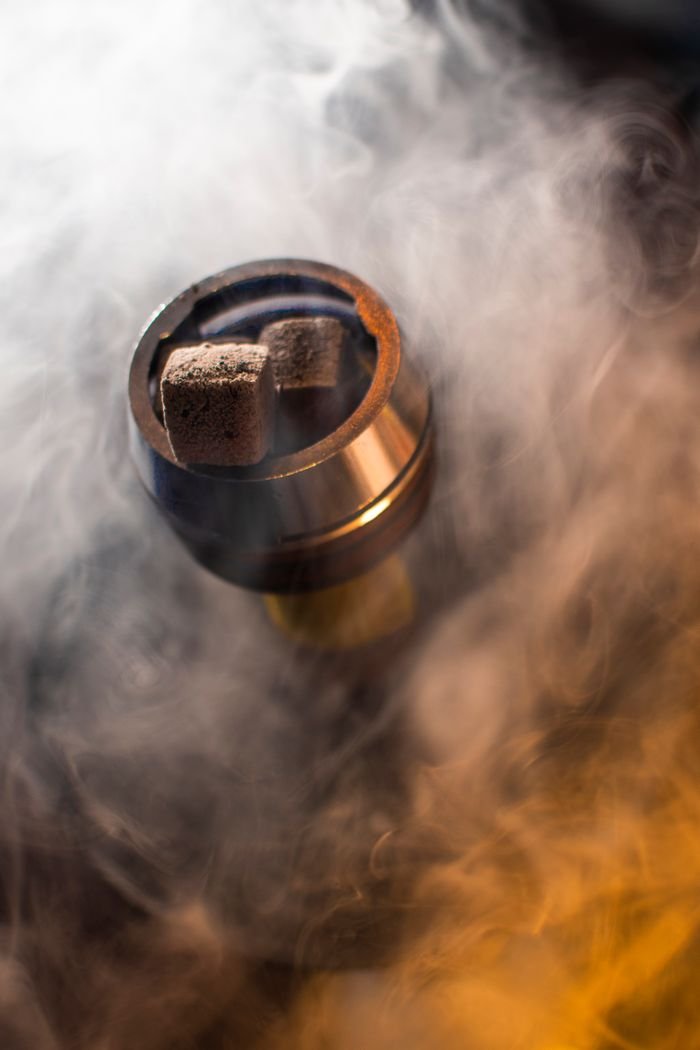 About Close-up shot of hookah coal emitting smoke, creating a vibrant atmosphere.
